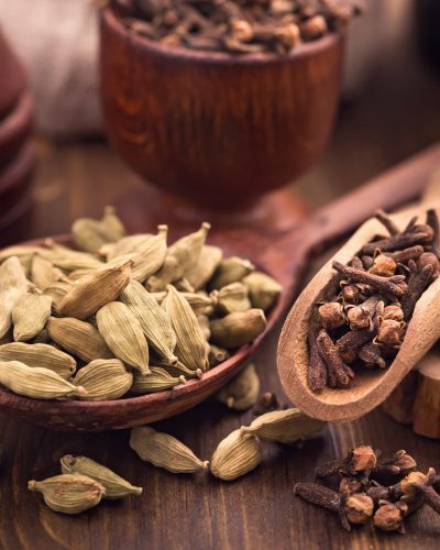 Clove and cardamom spices in scoops still-life